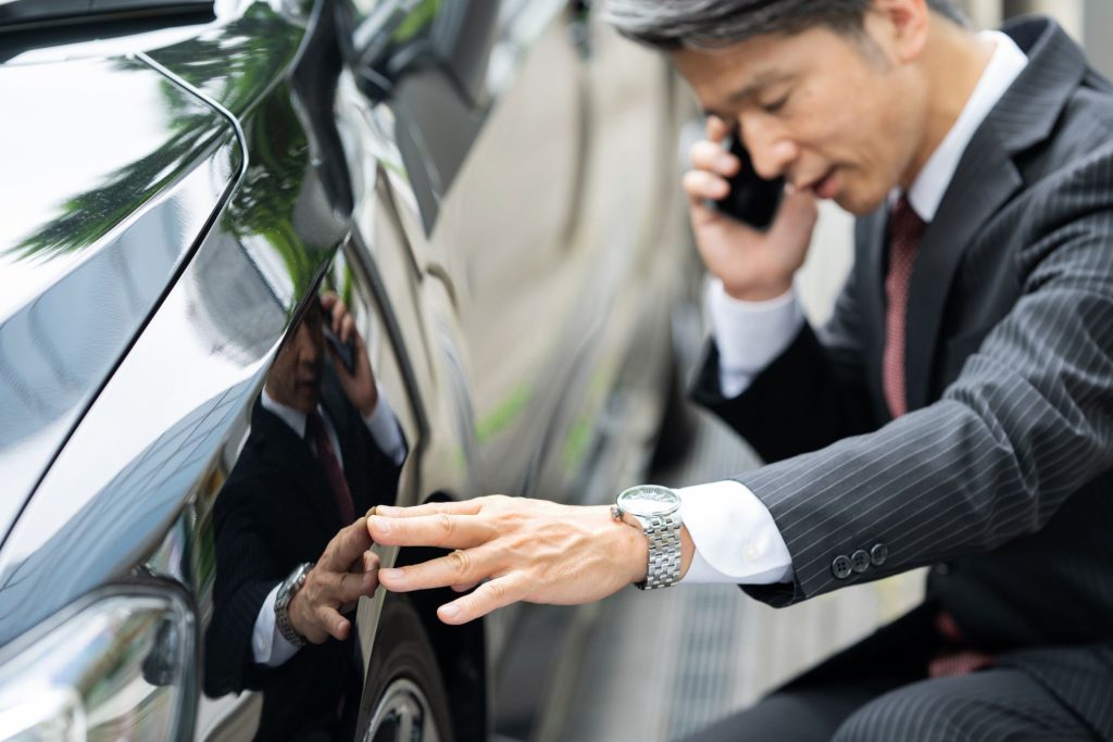 車の修理を呼ぶ男性